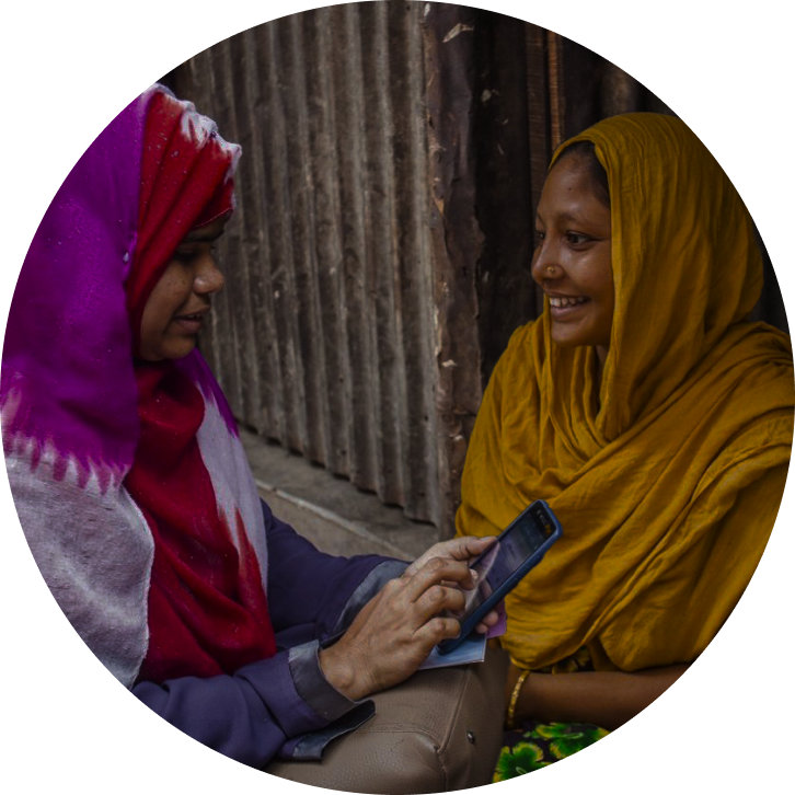 Deux femmes à l’extérieur en train de discuter tout en utilisant une application pour smartphone au Sri Lanka