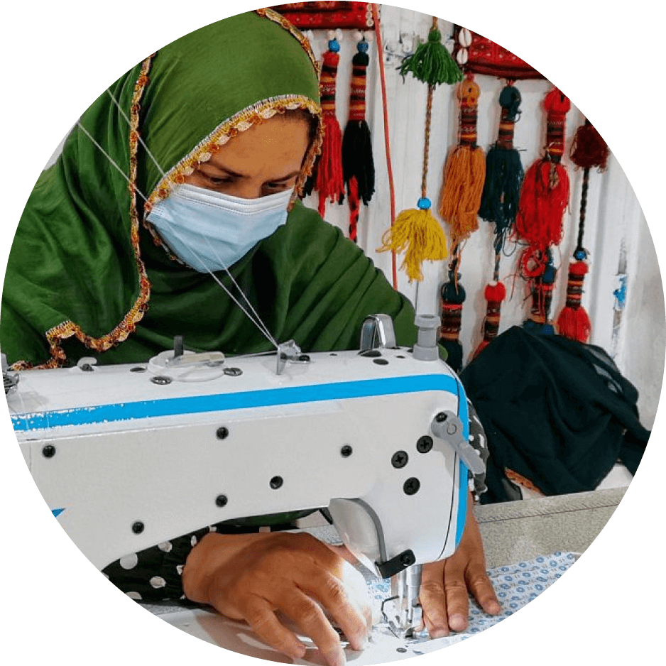 Woman wearing a headscarf, working at a sewing machine.