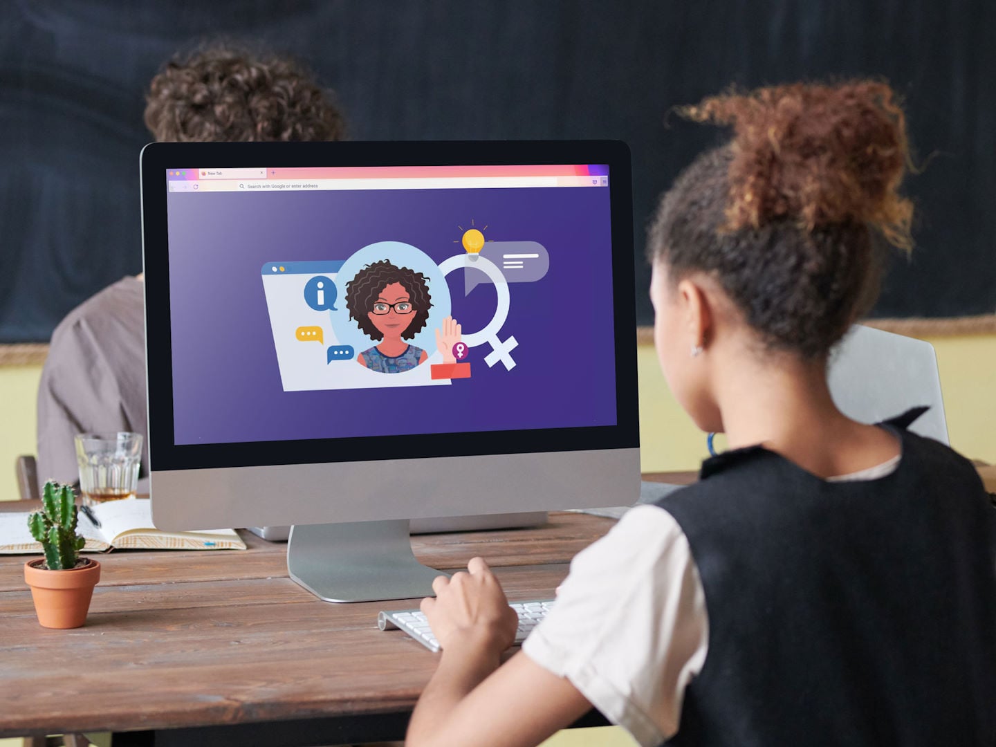 Una joven está delante de una pantalla de computadora en la que aparece el avatar de otra mujer invitándola a una discusión.