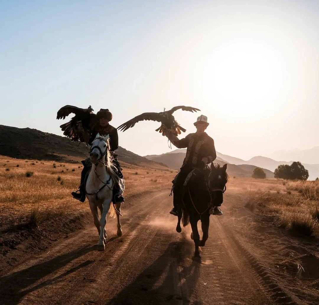 Eagle hunter riding into the distance at sunset